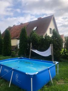 a blue pool in the yard of a house at Dom wypoczynkowy Zacisze in Filipów