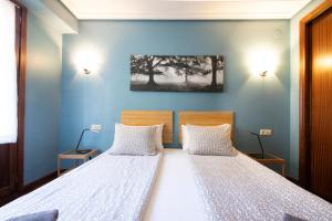 two beds in a room with blue walls at UBICACIÓN EXCELENTE para EXPLORAR la REGIÓN in Villabona