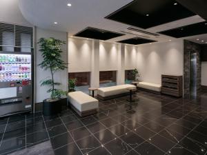 un vestíbulo de oficina con muebles blancos y una maceta en Hotel Mystays Kagoshima Tenmonkan Annex, en Kagoshima