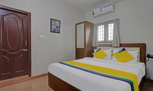 Itsy By Treebo - Rithika Inn Blossoms في تشيناي: غرفة نوم مع سرير كبير مع بطانية ملونة