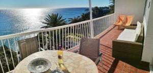 a table on a balcony with a view of the ocean at Carabeo Vista Mar in Nerja