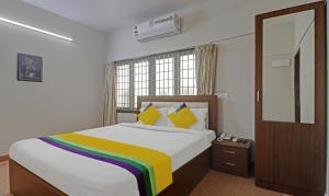a bedroom with a bed with a rainbow blanket at Itsy Hotels Rithika Inn Blossoms in Chennai