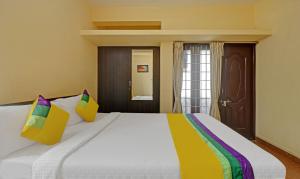 a bedroom with a large white bed with colorful pillows at Itsy Hotels Rithika Inn Blossoms in Chennai +33 photos