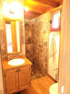 a bathroom with a sink and a stone wall at Fuerte Action Guest House in Costa Calma