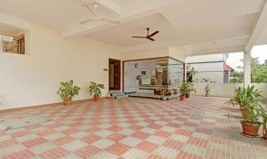 an empty room with potted plants and a ceiling fan at Itsy Hotels Rithika Inn Blossoms in Chennai