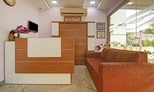 een woonkamer met een bank en een tv bij Itsy By Treebo - Rithika Inn Blossoms in Chennai
