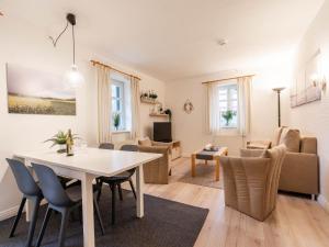 a living room and dining room with a table and chairs at Feriendorf Rugana - Komfort Appartement mit 1 Schlafzimmer und Terrasse B16 in Dranske