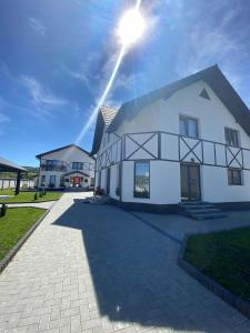 a white house with the sun shining on it at Vila RAIRA 2 in Barcani