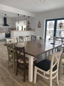 a kitchen and dining room with a wooden table and chairs at Vila RAIRA 2 in Barcani +3 photos