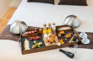 a tray with food and drinks on a bed at Porta Nova Suites Altea - Adults Only in Altea