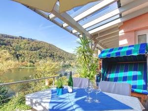 Ferienhaus Bullay في بولاي: طاولة مع كؤوس للنبيذ وإطلالة على النهر