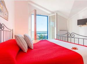 una camera da letto con un letto rosso e una grande finestra di Punta Est A due passi dal MARE a San Salvo