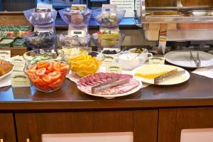 un mostrador con diferentes tipos de comida en platos en Pioneer Luxe Hotel, en Saratov