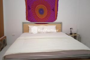 サバンにあるPasifik Hotel Sabang Mitra RedDoorzのベッドルーム1室(赤いパートナーの看板付)