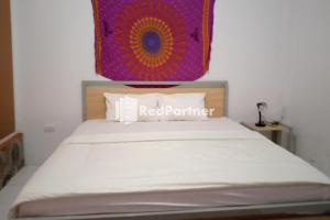 a bedroom with a bed with a red partner sign on it at Pasifik Hotel Sabang Mitra RedDoorz in Sabong