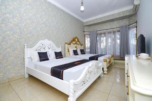 a bedroom with two beds and a tub and a sink at Guest House Gethsemane in Salatiga