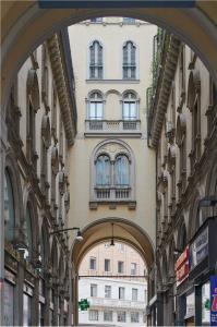 un arco que conduce a un edificio con ventanas. en Amabilia Suites en Milán