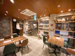 a restaurant with wooden tables and green chairs at Kobe Nadeshikoya in Kobe