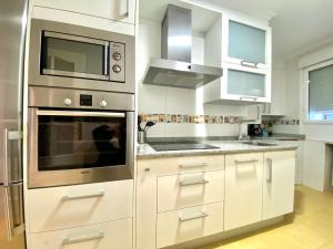 a kitchen with white cabinets and a microwave at Housingleón San Isidoro in León