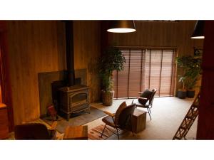 sala de estar con chimenea, sillas y fogones en Tokitama Himitsumichi COMORIVER - Vacation STAY 43686v en Banshō