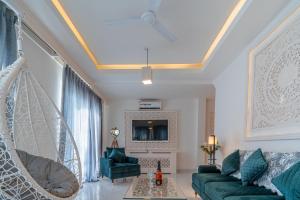 sala de estar con sofá verde y columpio en Lillywoods Zac Beach Resort, Calangute en Goa Velha