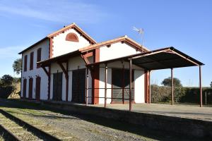 a train station with a white building next to train tracks at Casa Rural ESTACIÓN DEL SOLDADO in Estación del Soldado