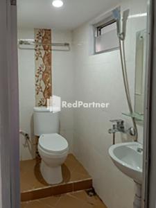 ein Badezimmer mit einem weißen WC und einem Waschbecken in der Unterkunft Hotel Trikatu Kendal near Taman Kota Weleri Mitra RedDoorz in Kendal