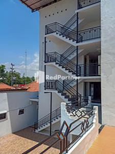 einen Balkon mit Treppen auf einem Gebäude in der Unterkunft Hotel Trikatu Kendal near Taman Kota Weleri Mitra RedDoorz in Kendal