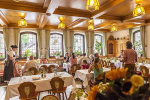 a group of people sitting at tables in a restaurant at BLÖDEL Gasthof Grüner Baum in Nürnberg