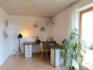 an office with a desk and a plant in a room at Ferienwohnung Schäfer mit direktem Zugang zum Garten in Windberg