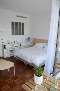 a bedroom with a white bed and a wooden floor at Appartement design avec terrasse in Paris