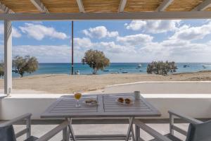 a picnic table with a view of the beach at Aqua Bay Agia Kyriaki in Agia Kiriaki Beach