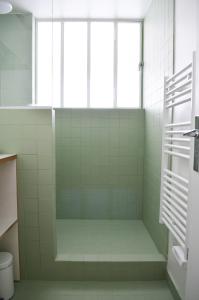 La salle de bains est pourvue d'une douche et d'une fenêtre. dans l'établissement Appartement design avec terrasse, à Paris