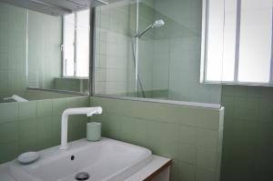 La salle de bains blanche est pourvue d'un lavabo et d'un miroir. dans l'établissement Appartement design avec terrasse, à Paris