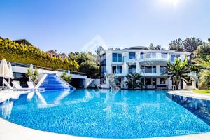 a large swimming pool in front of a house at Villa Yalcin in Kuşadası