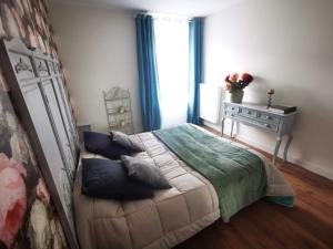 a bedroom with a bed and a table and a window at Le 2 BIS in Langres