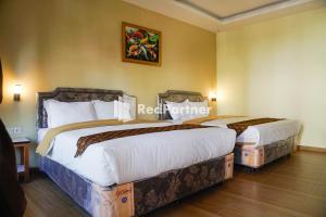 Tempat tidur dalam kamar di Griya Imafa Inn Mitra RedDoorz