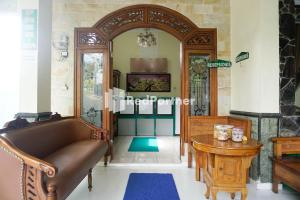 a living room with a couch and a table at Griya Imafa Inn Mitra RedDoorz in Tlekung