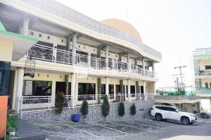 a white car parked in front of a building at Griya Imafa Inn Mitra RedDoorz in Tlekung