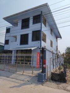 Biały budynek z płotem przed nim w obiekcie SRS3 STUDIO APARTMENT w mieście Ban Bang Kha