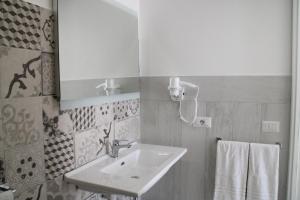 a bathroom with a sink and a mirror at La Guitgia Rooms in Lampedusa