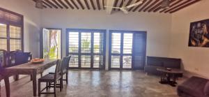 a living room with a dining room table and chairs at Villa Malaika in Jambiani
