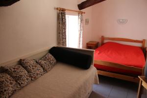 a bedroom with a red bed and a window at Le Coq en Pâte in La Roque-Esclapon