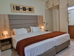 イラクリオン・タウンにあるCasa Centraleのベッドルーム1室(白いシーツと茶色の毛布を使用した大型ベッド1台付)