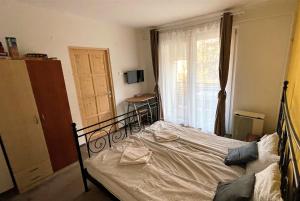 a bedroom with a bed and a window and a window at Évi Apartman in Eger