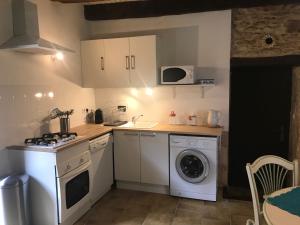 a kitchen with a washing machine and a washer at Gîte Le Meynet in Saint-Cyprien
