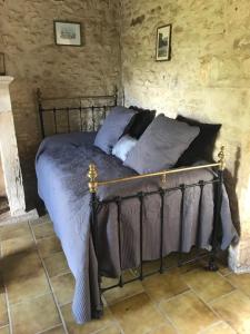 a bedroom with a bed in a stone wall at Gîte Le Meynet in Saint-Cyprien