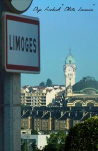 a sign in front of a building with a clock tower at Hôtel du Parc Limoges in Limoges
