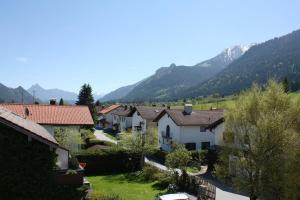 a village with houses and mountains in the background at Haus Bergland in Pfronten