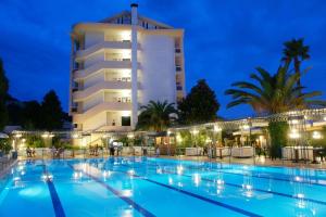 a swimming pool in front of a hotel at night at Hotel Mirasole International in Gaeta